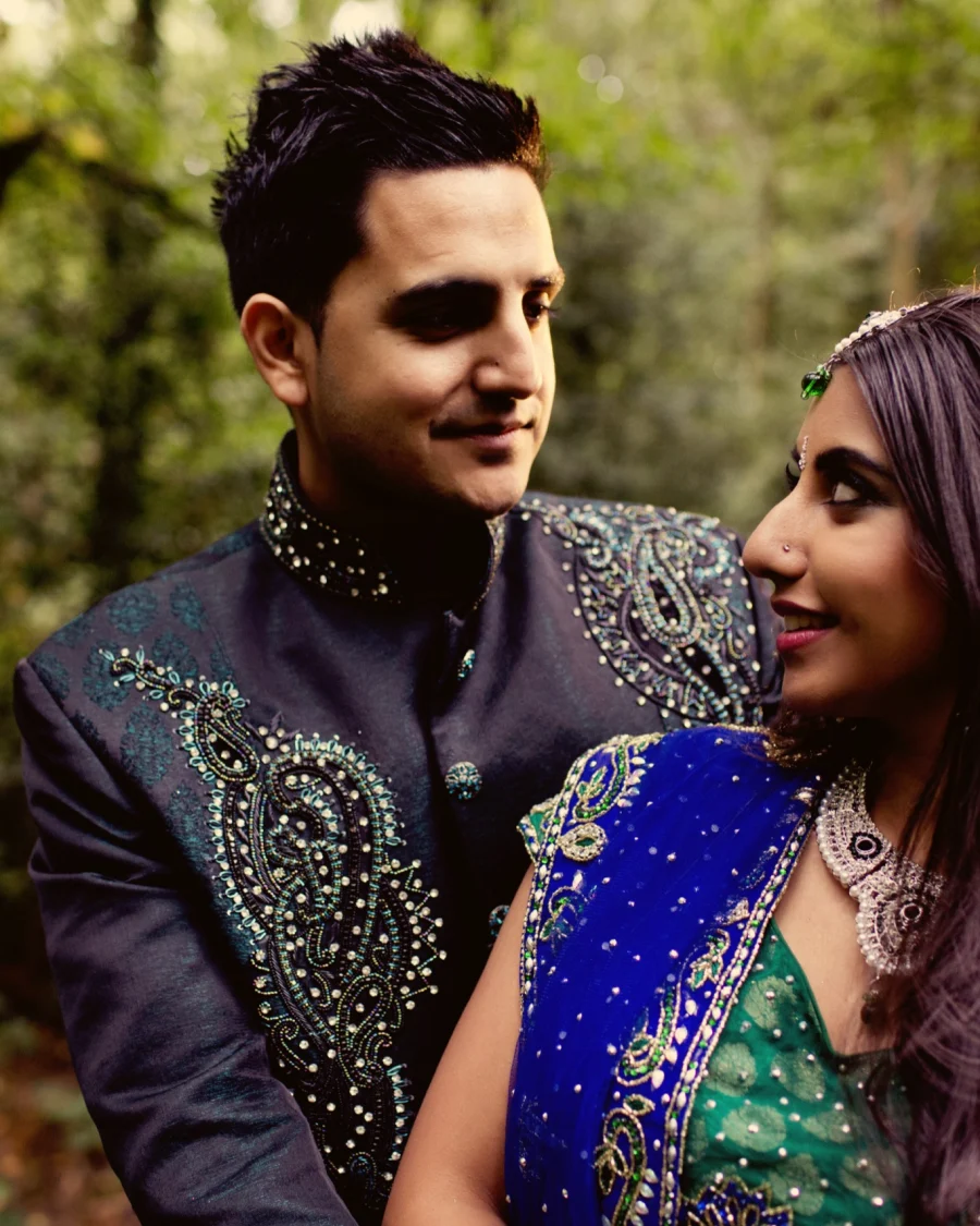 Asian bride and groom in green and gold wedding outfits