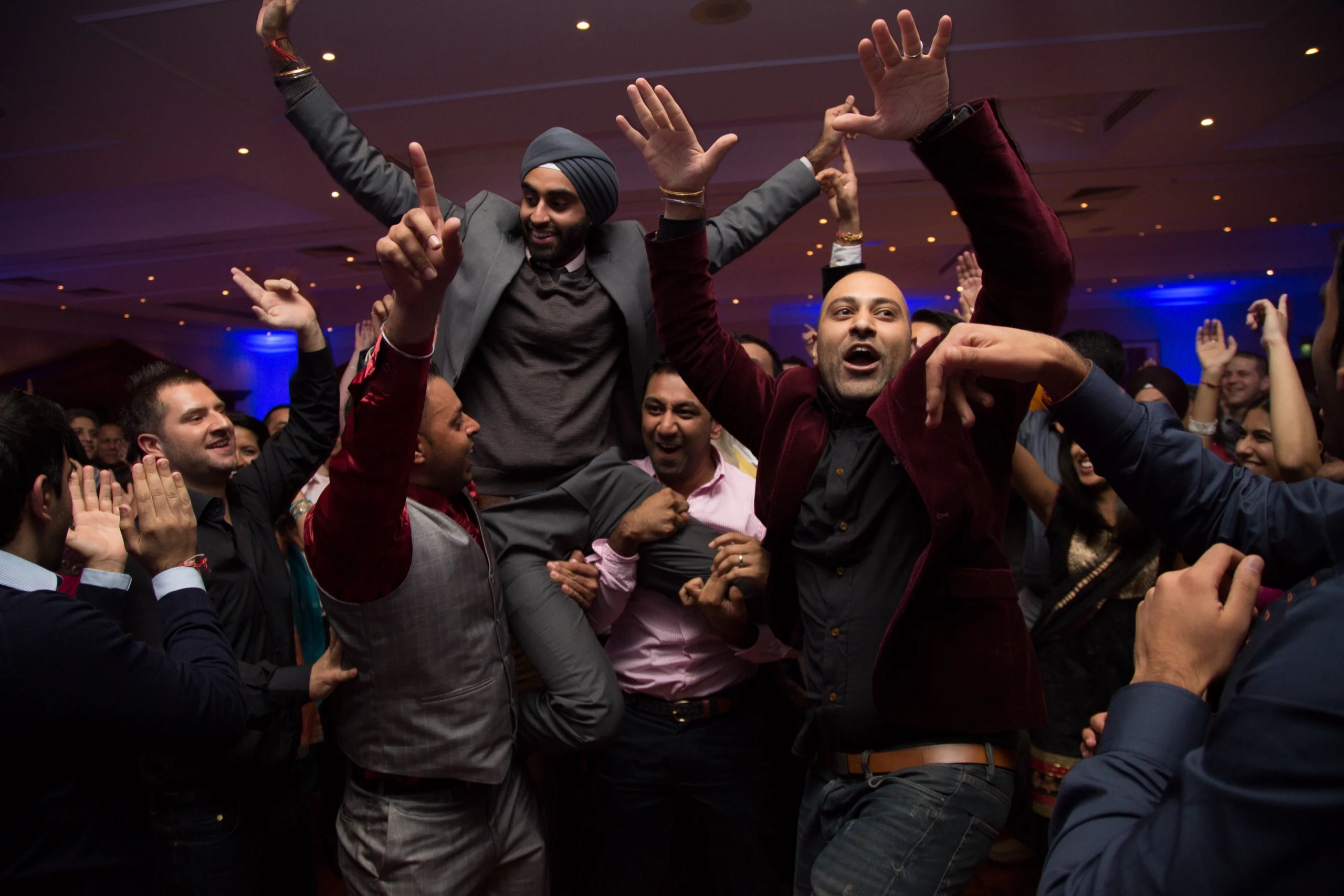Guests dancing with their hands in the air at a wedding party